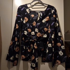 Blus öppen rygg - Strl. 38. Svart, blommig Sparsamt använd