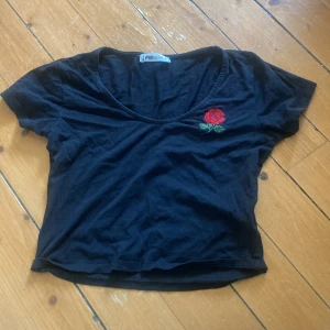 Svart croptop  - En svart croptop med en broderad ros på bröstet💕🌹
