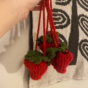 Jordgubbs påse - En liten påse i form av en jordgubbe som man sätter på andra väskor. 