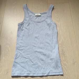 Ribbat blått linne - Ribbat ljusblått linne. Ganska långt. Använd fåtal gånger, legat i garderoben ett tag utan användning efter köpet i somras, storlek S men stretchig så kan passa större storlekar, inget tydligt slit.