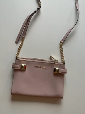 Rosa michael kors väska - En oanvänd michael kors väska som jag har haft i 6 år utan användning. Den är i nästan nytt skick. Originalpris ligger runt 3000kr