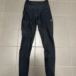 Zaczess ridbyxor  - Svarta Zaczess ridtights i storlek XS (mer som en S). Inga defekter förutom det på bild 3 och 4, tråden i sömmarna har gått av på sidorna av rumpan. Sytt på ena sidan. Inget som påverkar funktionen och det går ju att göra något snyggare. Helskodda