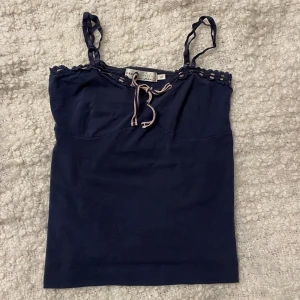 Blått linne med rosett - Gulligt linne! Liten i storleken. 