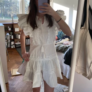 Vit klänning - Supersöt klänning som är perfekt till studenten! Finns ett band till att knyta runt midjan.