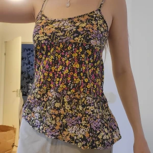 Y2K blommigt linne - Inköpt mellan år 2000-2010. Sött linne med blommigt mönster och lite utsvängt. Jätteluftigt och i bomull, passar därför perfekt i sommar 🥰. Passar även XS. Svarar på alla frågor.