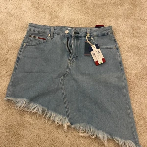 Tommy Hilfiger kjol  - Säljer min Tommy Hilfiger kjol som är helt oanvänd då den inte kommer till användning. Storlek 27 men passar mig som har S/M. Org pris 750, säljer för 200. Vid frågor är det bara att skriva.