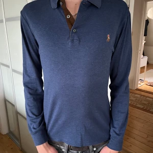 Ralph Lauren Rugby shirt - Fräsch Ralph Lauren rugby tröja i färgen blå och passar storleken S. (Ny pris 1500) Tröjan är i mycket bra skick och använd ett fåtal gånger då den vuxits ur. 