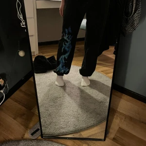 Svarta mjukisbyxor med blått - Svarta mjukisbyxor från SHEIN med blå blixt och blåa fjärilar. Inköpta 2021 och inte använda särskilt mycket. Säljer för att det är för små.