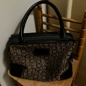 Calvin Klein väska - Väska i bra skick. Defekter finns (se bilder) Men fortfarande i riktigt bra skick och inget som syns eller tänks på vid användning