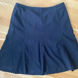 Svart kostymkjol i strl 44 med foder - Svart kostymkjol i strl 44 med foder.  Mått Midjan: ca 46 cm Längd: ca 60 cm  Material: 66% polyester, 17% ull, 15% viskos och 2% elastan  Använda men i fint begagnat skick.  Kommer från ett djur och rökfritt hem