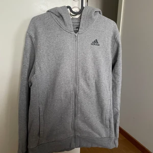 Adidas grå hoodie storlek M - Grå adidas kofta / hoodie / zip-up i storlek M med svart logo på armen