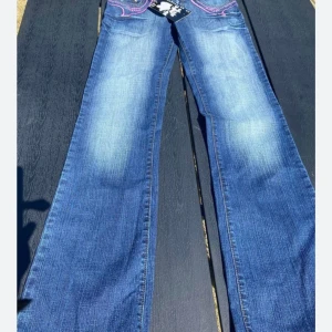 Supertrendiga lågmidjade bootcut jeans helt nya - Helt nya supersnygga jeans med tagg kvar . Sliten look , fina detaljer vid fickor , snygga knappar, låg midja samt lite utsvängda . Har storlek 27 och 28 kvar . Nypris 399 . 