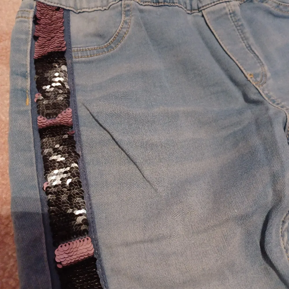 Säljer nu dessa coola och unika jeans som är blå med paljetter på sidorna som är svarta och rosa. De är sparsamt använda och därför i bra skick. Storleken är 164 men passar också xs . Jeans & Byxor.