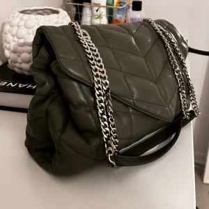 Väska - Säljer min fina väska köpt hos Zalando. Väskan är numera slutsåld. Den är stor och rymlig, perfekt att ha som skolväska. Kedjorna går att justeras, kan bäras över axeln eller som crossbody. I superfint skick nästan aldrig använd. 