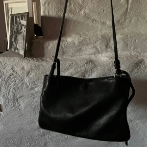 COS axelremsväska ÄKTA!  - Här har vi en svart axelremsväska från cos i äkta läder!  Den är väldigt praktisk och har tre fack för förvaring!! 😍