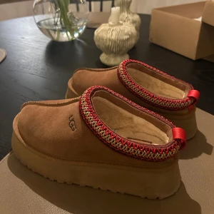 UGG Tazz Slipper 'Chestnut' - Säljer nu mina UGG tazz då jag redan äger ett par andra uggs och känner att de inte kommer till användning. De är i fint skick och har inga märkbara defekter, original låda finns. Storlek 36. Nypris 2000 säljer för 1250 eller vid högsta prisförslag! 
