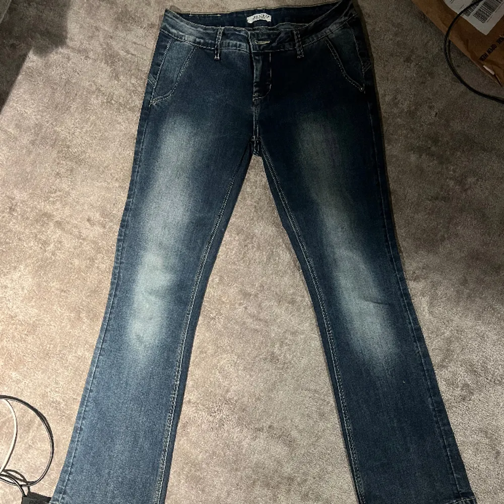 Säljer dessa snygga lågmidjade jeans med coola detaljer baktill. De är köpta second hand och i fint skick. Passar bra på mig som är 1,65💕. Jeans & Byxor.