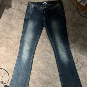 Lågmidjade jeans  - Säljer dessa snygga lågmidjade jeans med coola detaljer baktill. De är köpta second hand och i fint skick. Passar bra på mig som är 1,65💕