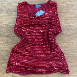 Röd paljettlinne från Adrianna Papell - Ett glittrande rött linne från Adrianna Papell, täckt med paljetter. Linnet har en rund halsringning och är ärmlöst, perfekt för festliga tillfällen.🥳🥳 Lapparna kvar! Står strlk 14 på lappen men skulle uppskatta M-L💓