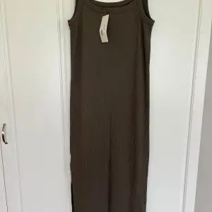 Clean dress, långklänning i ribbad trikå från house of lola. Färg falcon brown. Helt ny och oanvänd med lappar kvar.