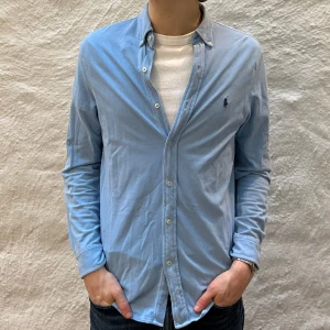 Ralph Lauren skjorta  - Ralph lauren skjorta i färgen blå. Storlek M och modellen är 186 cm. Nyskick, inga skavanker. Nypris 1699kr kr, köp för endast 599kr.