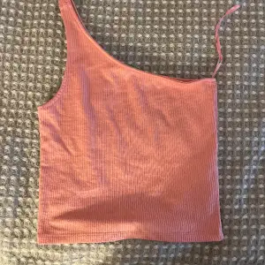 Rosa croppat linne med en ärm från Gina tricot. Storlek XS. Aldrig använd.