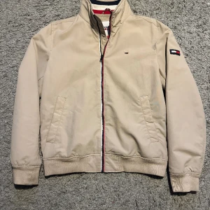 Tommy Hilfiger Vårjacka - Säljer en stilfull Tommy Hilfiger- vårjacka i storlek M, men passar storleken S bra (själv bär jag S). Den är i väldigt bra skick. Inköpt för 1000 kronor i Tommy Hilfiger-butiken i Barkarby. 