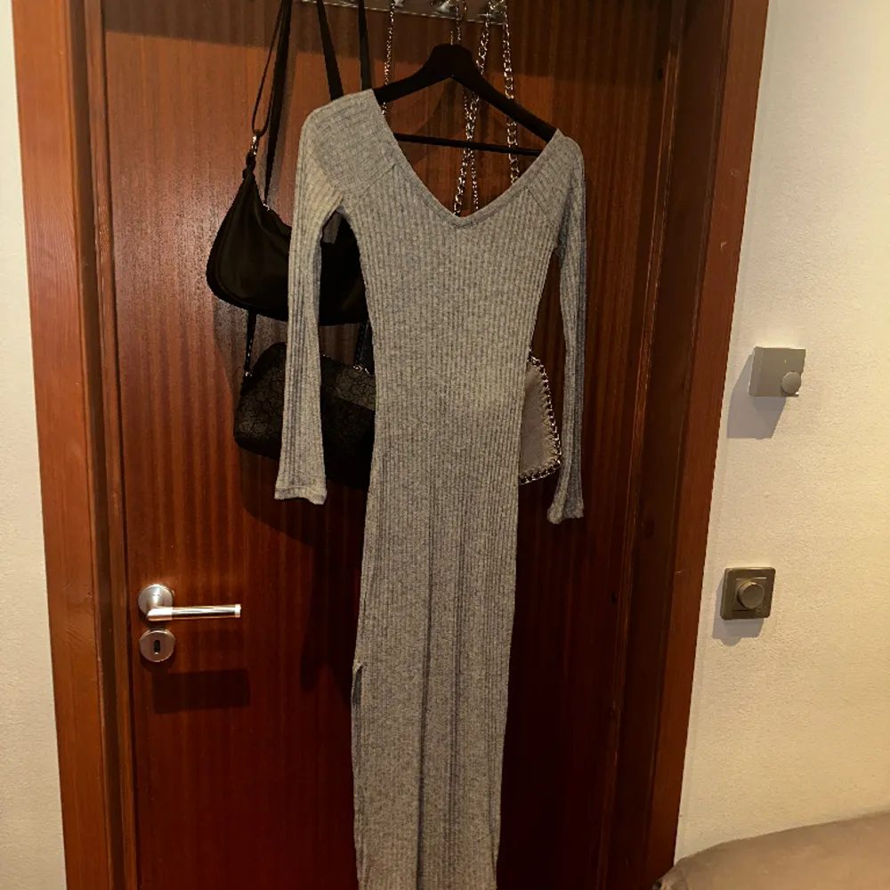 En lång grå tyg klänning som formar sig efter figuren, med slits på sidan! Väldigt skönt material och helt oanvänd med prislapp kvar!🩶Storlek XS 🩶. Klänningar.