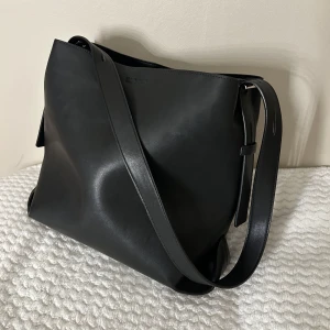 Svart axelremsväska  - Säljer denna super fina axelremsväska, köpt på Nelly.com (märket pieces). Säljer då den inte kommer till användning längre.