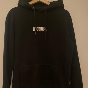 Hoodrich hoodie - En fin hoodrich hoodie säljer pga ingen användning. Sparsamt använd och är i fint skick. Passformen passar både dam och herr den är i S passar även XS-M. Har en liten ficka på ena underarmen. Vid fler frågor hör av dig. Frakt ingår ej.