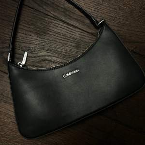 En svart väska från Calvin Klein.