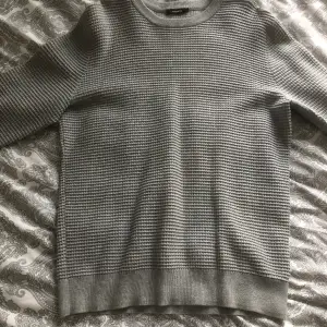 En grå tröja från märket J.Lindeberg storlek L sitter väldigt bra, knappt använd