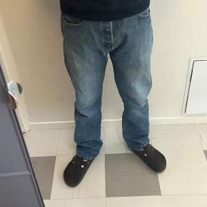 Snygga Levis 501 jeans i ett super skick. Tvätten är ganska trött ljus och de är raka i modellen. De passar på både män och kvinnor i storlek W34 L32