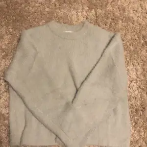En stickad tröja som aldrig används. Den är i ett tungt och rejält material med fluff. Färgen är en blandning mellan mintgrön och ljusblå 😊
