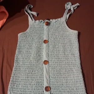 Blått linne  - Jätte gulligt blått linne med knappar och snörning. Använd några gånger men är i bra skick 