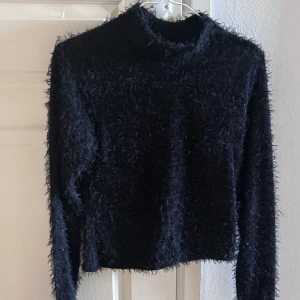 Svart lurvig tröja - En svart lurvig tröja från Nelly i storlek XS