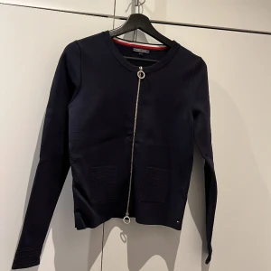 Cardigan med zipper - Marinblå cardigan med zipper från Tommy Hilfiger, enbart använd ett fåtal gånger. Ordinarie pris 1500kr