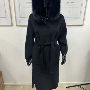 En lång svart kappa med äkta avtagbar päls Helt ny och oanvänd finns storlek S & M 
