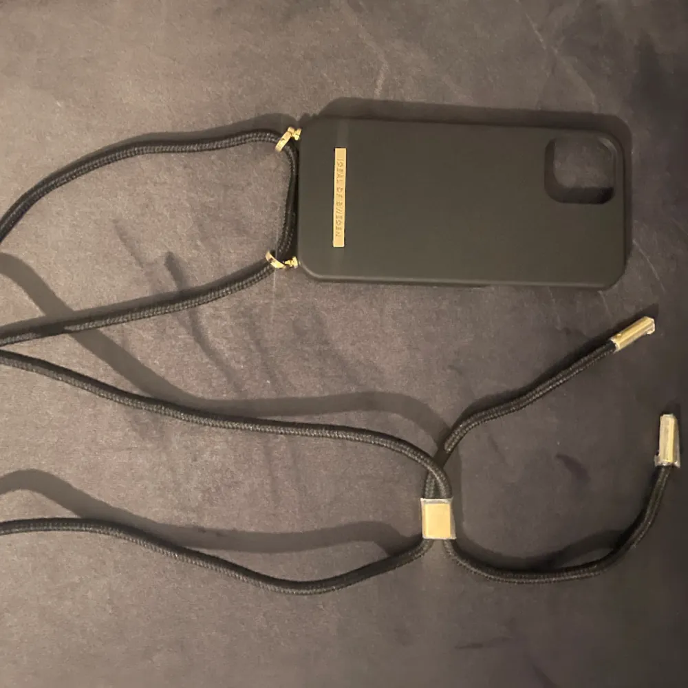 Säljer detta silikon iPhone skalet från ideal of Sweden, passar iPhone 12 och 12pro, har även ett band så den kan bli lite som en väska, säljs då den inte används💕. Accessoarer.