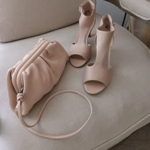 Puderrosa clutch/crossbody och sandaletter i äkta skinn. - Läcker puderrosa clutch/crossbody från Markberg i äkta skinn. Clarks sandaletter I puderrosa äkta skinn stl 39. Säljes som ett kit alternativt för sig. 