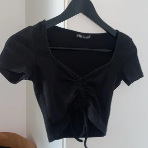 Svart croptop snörning - Säljer denna svarta croptop med snörning från zara. Bra att ha till tillfällen som fest osv. 