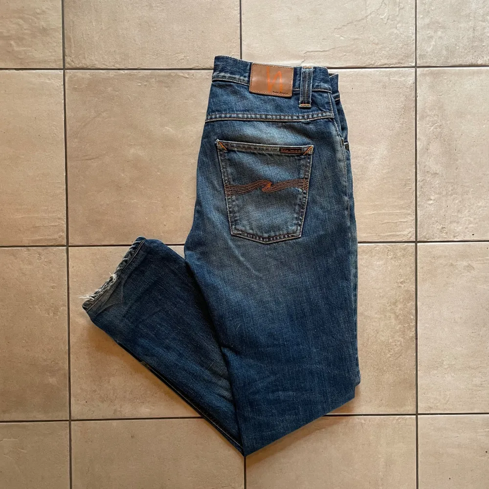 Nudie Jeans i modellen Grim Tim🕺| Skick: Fint skick med en riktigt snygg åldring/fade⭐️| Storlek: W32/L32 | Pris: 399✔️, Nypris: 1600kr❌| OBS! Hål på båda ben, som visas på bild två. Dessa kan lagas gratis på Nudie butik, jag kan lämna in efter köp🤝. Jeans & Byxor.
