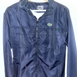 Lacoste vindjacka - Köptes utomlands. Har byxorna också till den om någon skulle vara intresserad  Den är i storlek S/XS Priset kan sänkas vid snabb affär 