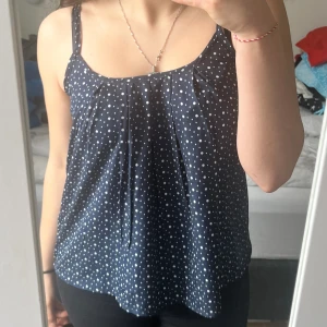 Topp  - Gullig topp till sommaren.  Blå med vita prickar. Luftig och skön. Väldigt tun men inte genomskinlig. 