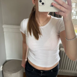 Figursydd T-shirt  - Vit, taight och figursydd basic T-shirt från ARKET. Är i mycket bra skick. Den är i storlek XS men passar mig som brukar ha storlek S. 