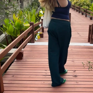 Linnebyxor  - Mörkgröna linnebyxor som är vida i benen.