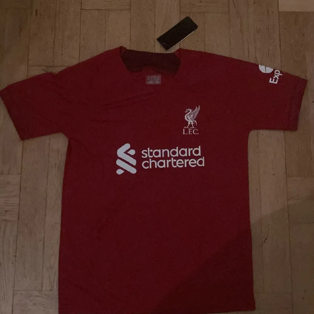 En helt ny Liverpool tröja med nummer 11 på ryggen salah. Tags sitter kvar på tröjan då den är oanvänd.. T-shirts.