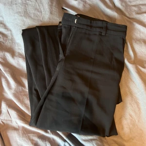 Kostymbyxor  - Svarta raka kostymbyxor i storlek 34 med fickor! 