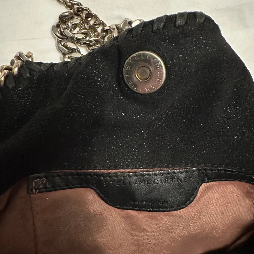 En perfekt mini väska från Stella McCartney i svart och guld (dock har färgen på kedjorna tonats bort). Inhandlad på plick för ca 1 år sen. Men nu får den komma till ett nytt hem som den kommer till användning mer!!. Väskor.