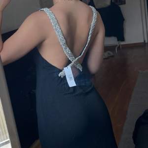 Oanvänd klänning med öppen rygg och ”strass” passar XS-M